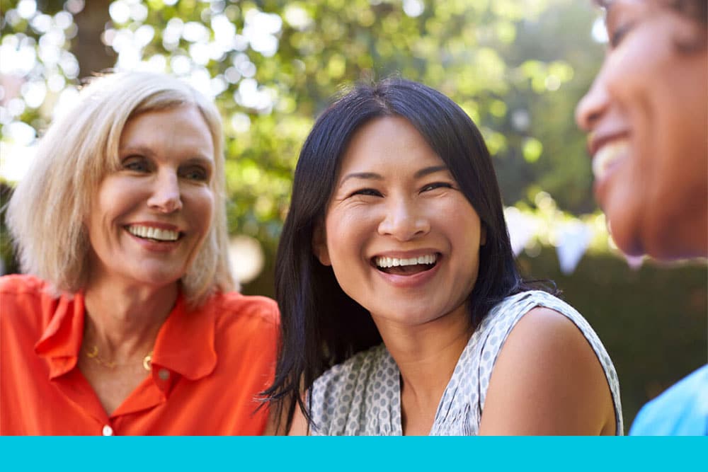 group of women smiling and talking outdoors